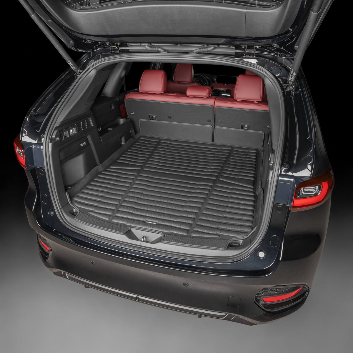 Open car trunk with red interior seats on a dark background